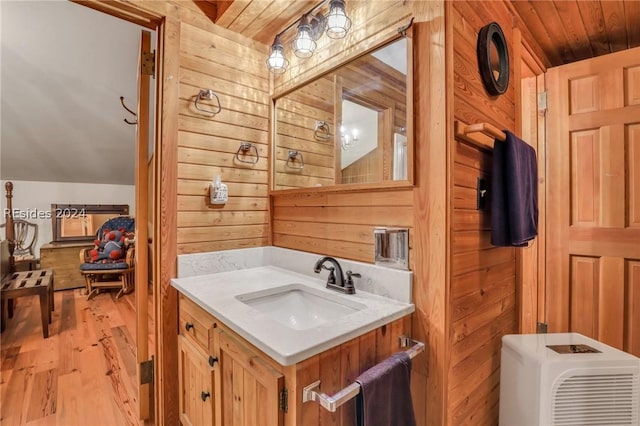 bathroom featuring vaulted ceiling, wooden walls, wood-type flooring, vanity, and wood ceiling