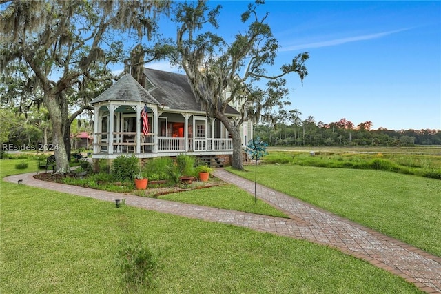 view of front facade featuring covered porch and a front lawn