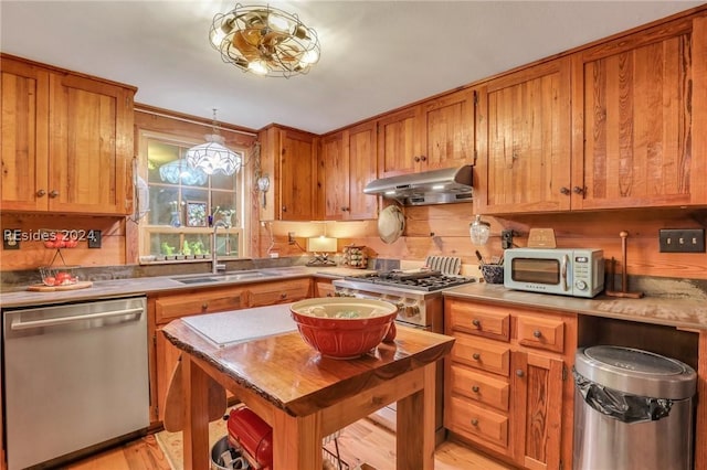 kitchen with stainless steel appliances, sink, and light hardwood / wood-style flooring