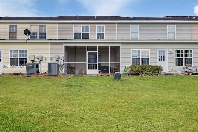 back of property with central AC unit, a yard, and a sunroom