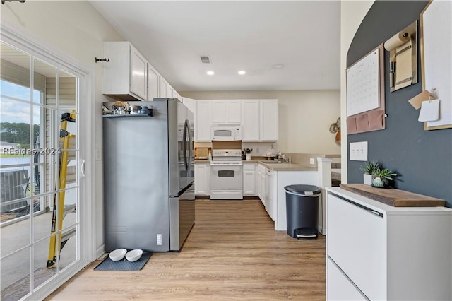 kitchen featuring sink, white appliances, light hardwood / wood-style flooring, and white cabinets