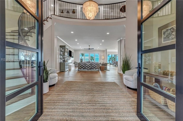 entryway featuring a high ceiling, wood-type flooring, a notable chandelier, and french doors