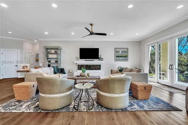 living room featuring hardwood / wood-style flooring, ornamental molding, french doors, and ceiling fan