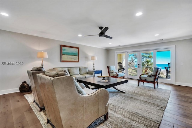 living room with dark hardwood / wood-style flooring, crown molding, french doors, and ceiling fan