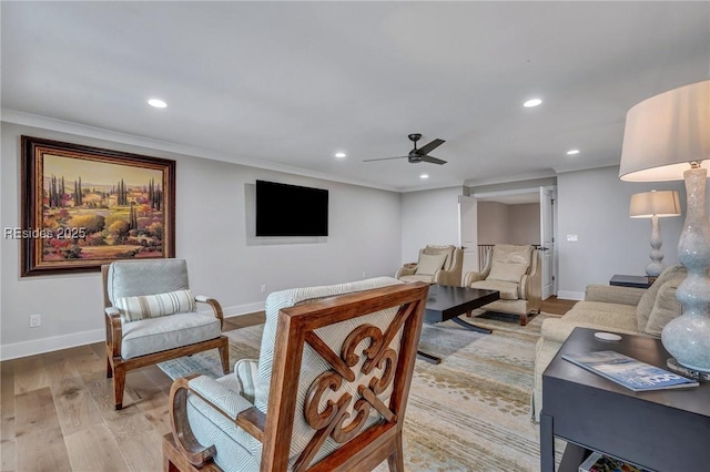 living room with ornamental molding, ceiling fan, and light hardwood / wood-style flooring