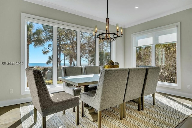 dining room featuring a water view, ornamental molding, plenty of natural light, and a notable chandelier