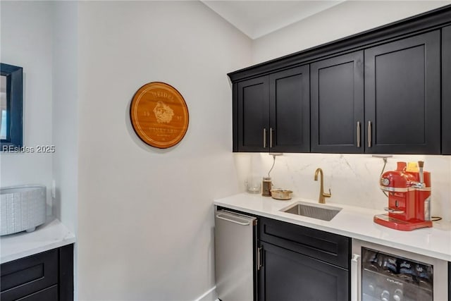 bar featuring sink, stainless steel dishwasher, and beverage cooler