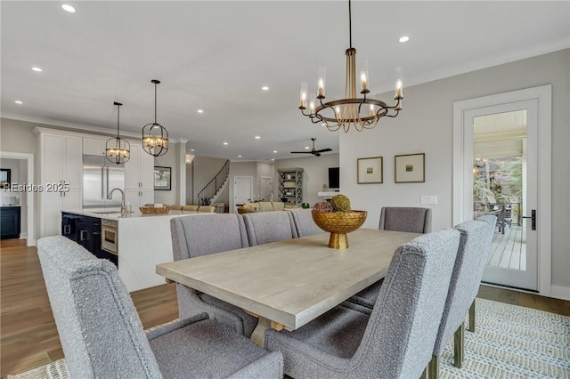 dining room featuring sink, a notable chandelier, and light hardwood / wood-style floors