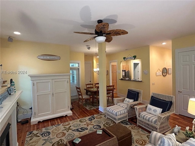 living room with dark wood-type flooring and ceiling fan