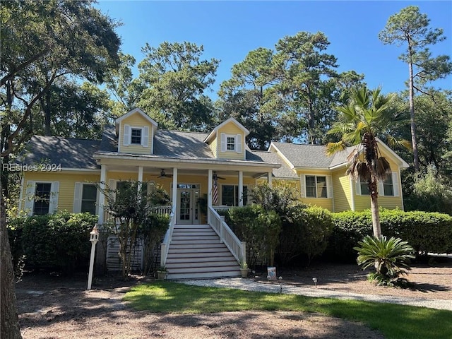 new england style home with ceiling fan and covered porch