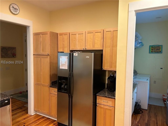 kitchen featuring light brown cabinets, dark stone countertops, dark hardwood / wood-style flooring, stainless steel appliances, and washer and clothes dryer