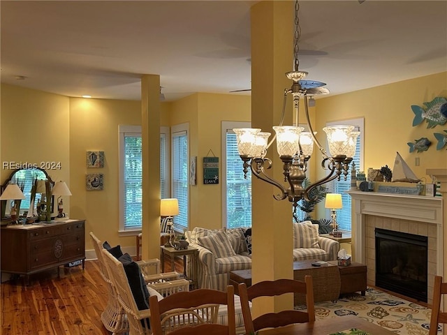 interior space with a tiled fireplace, hardwood / wood-style floors, and a notable chandelier