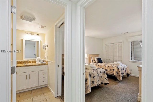 tiled bedroom with sink and a closet