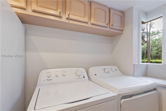 laundry area featuring cabinets, plenty of natural light, and washing machine and clothes dryer