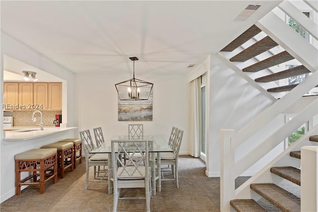 carpeted dining room with a notable chandelier and sink