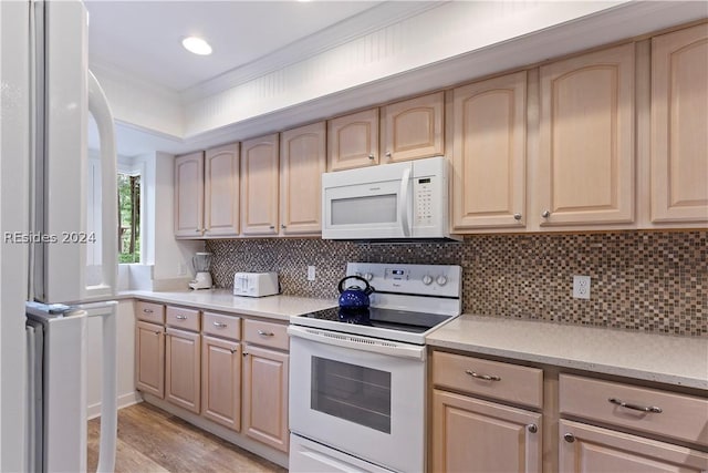 kitchen with light brown cabinetry, white appliances, and decorative backsplash