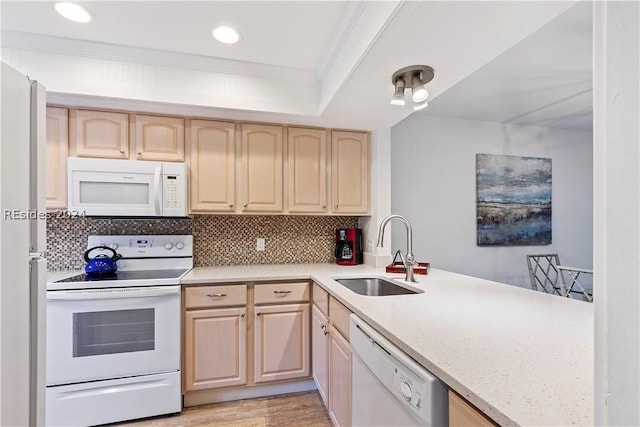 kitchen featuring sink, backsplash, light brown cabinetry, and white appliances