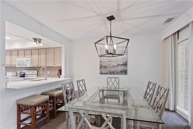 dining area featuring sink and dark colored carpet