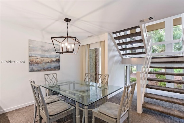 carpeted dining area featuring a chandelier