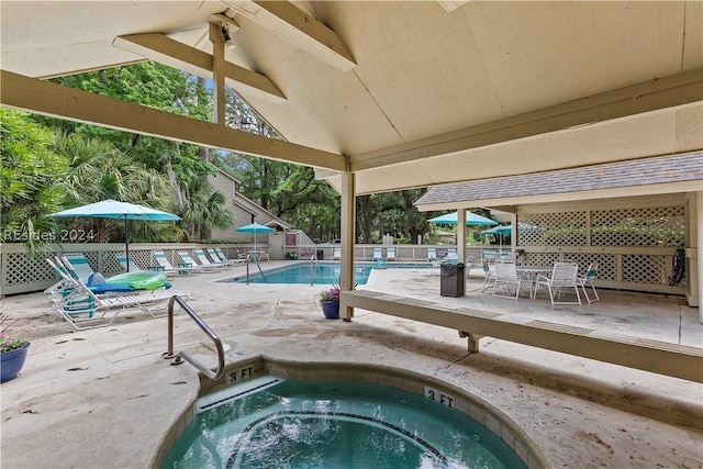 view of pool with a hot tub and a patio