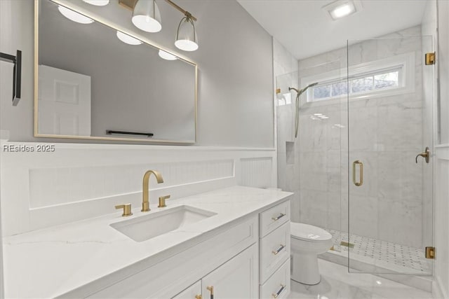 bathroom featuring vanity, toilet, and a shower with shower door