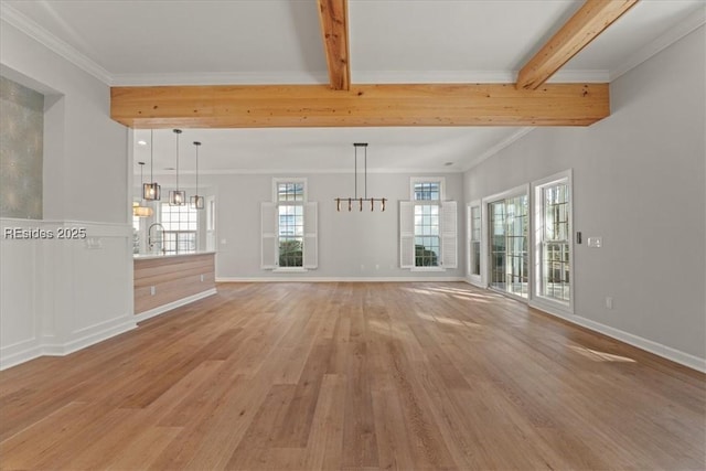 unfurnished living room featuring crown molding, wood-type flooring, beam ceiling, and sink