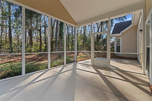 unfurnished sunroom featuring vaulted ceiling