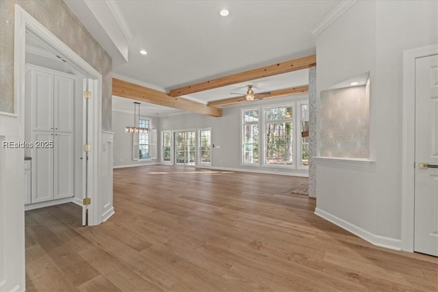 unfurnished living room featuring plenty of natural light, ornamental molding, and light hardwood / wood-style floors