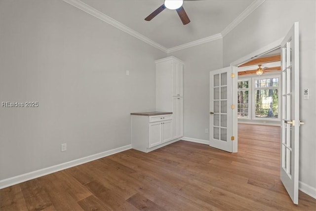 spare room featuring french doors, ceiling fan, ornamental molding, and light hardwood / wood-style flooring