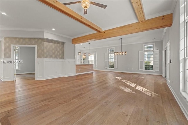 unfurnished living room with a healthy amount of sunlight, beam ceiling, and light hardwood / wood-style flooring