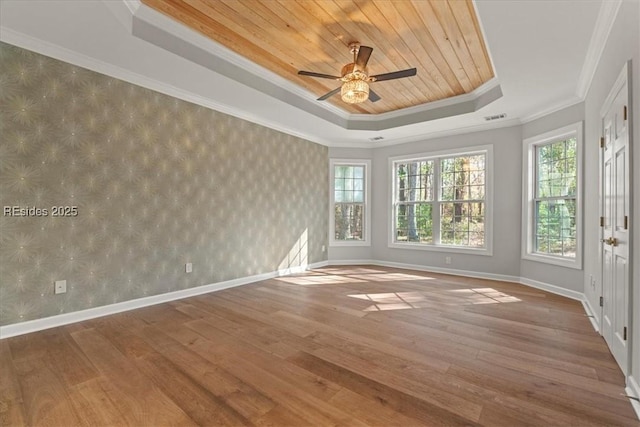 unfurnished room featuring hardwood / wood-style flooring, ceiling fan, a tray ceiling, crown molding, and wooden ceiling