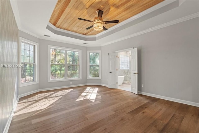 empty room featuring crown molding, a raised ceiling, light hardwood / wood-style floors, and wooden ceiling