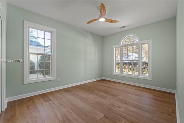 spare room featuring ceiling fan, a wealth of natural light, and light hardwood / wood-style floors