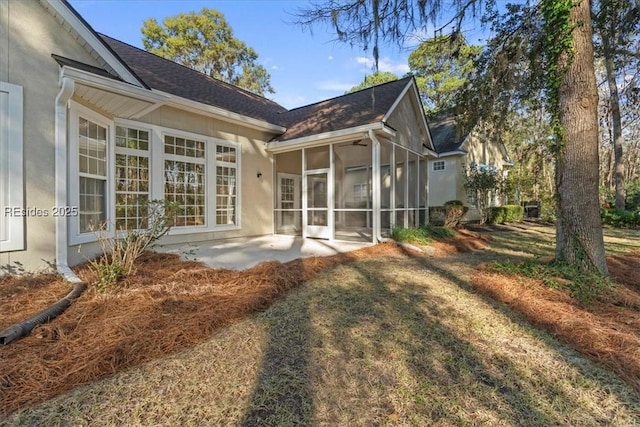 rear view of house featuring a yard, a patio area, and a sunroom