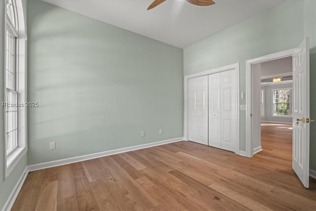 unfurnished bedroom with light hardwood / wood-style flooring, a closet, and ceiling fan