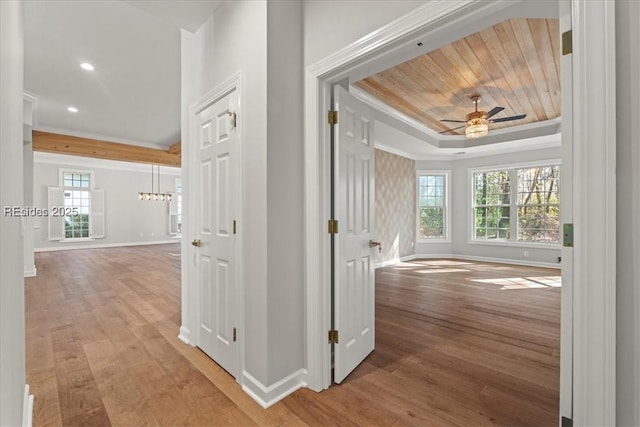 corridor with hardwood / wood-style floors, a tray ceiling, and wooden ceiling