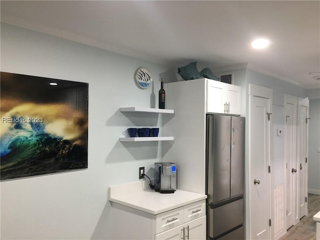 kitchen featuring stainless steel refrigerator, white cabinetry, ornamental molding, and light wood-type flooring