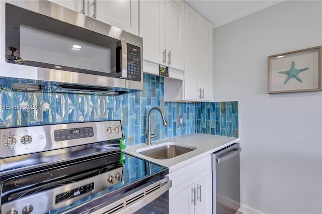 kitchen with sink, crown molding, appliances with stainless steel finishes, white cabinetry, and decorative backsplash