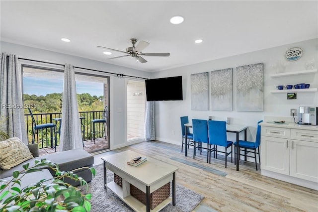 living room with ceiling fan and light hardwood / wood-style flooring