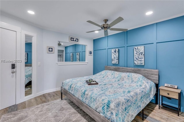 bedroom featuring wood-type flooring, ornamental molding, and ceiling fan