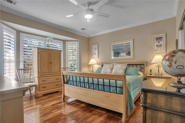 bedroom with ceiling fan, crown molding, hardwood / wood-style floors, and a textured ceiling