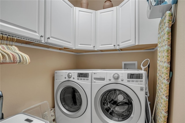 clothes washing area featuring cabinets and independent washer and dryer