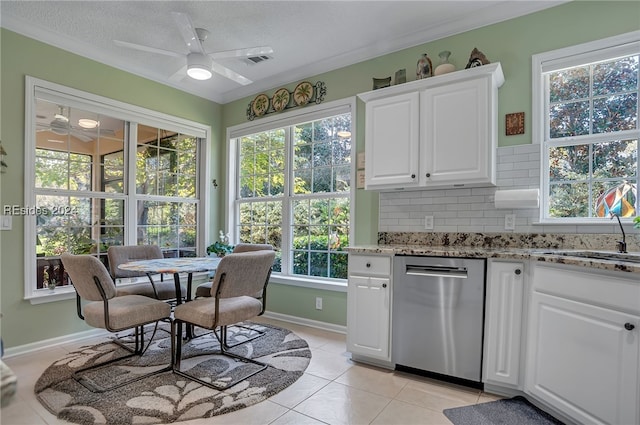 kitchen featuring light tile patterned floors, dishwasher, tasteful backsplash, white cabinets, and a healthy amount of sunlight