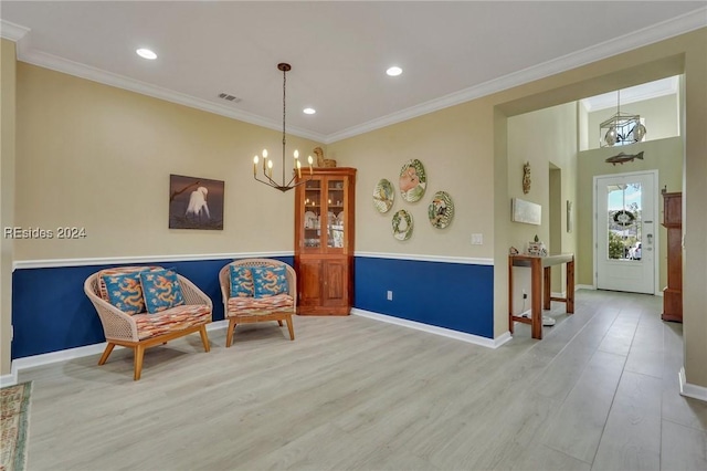 sitting room featuring ornamental molding, light hardwood / wood-style floors, and a notable chandelier