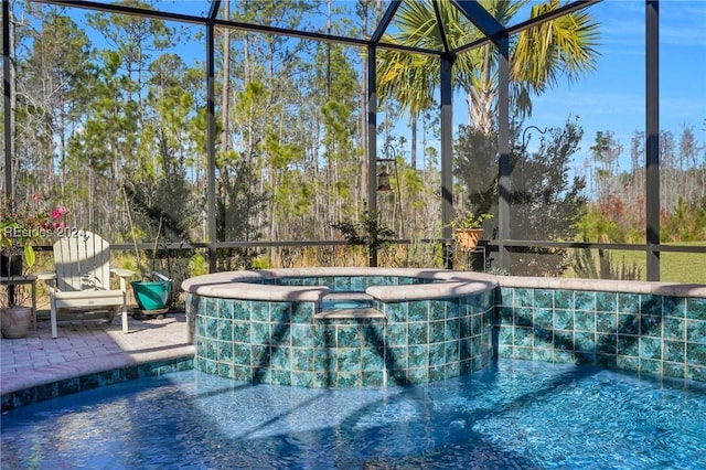 view of pool with a lanai and an in ground hot tub