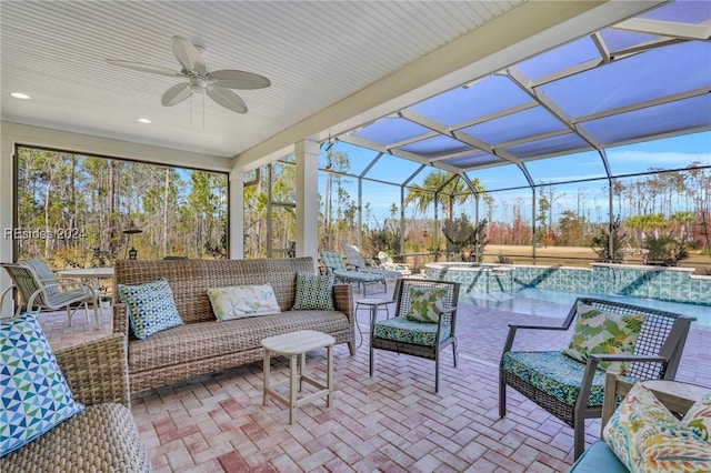 view of patio / terrace with a swimming pool with hot tub, an outdoor living space, a lanai, and ceiling fan