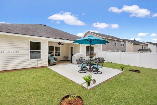 back of property with a lawn, a patio, and ceiling fan