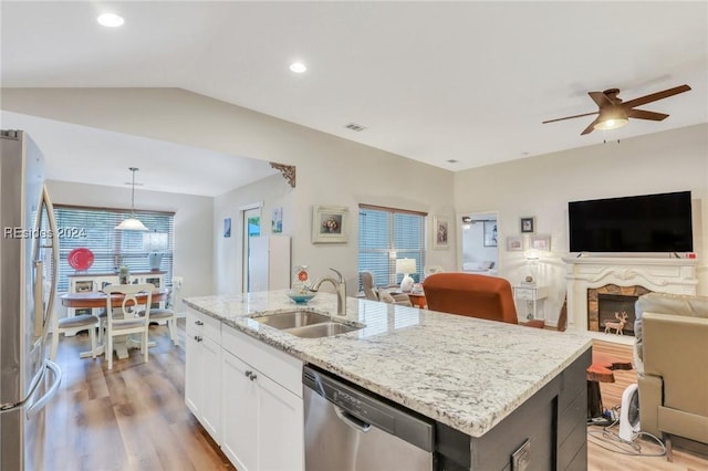 kitchen featuring white cabinetry, sink, hanging light fixtures, a kitchen island with sink, and stainless steel appliances