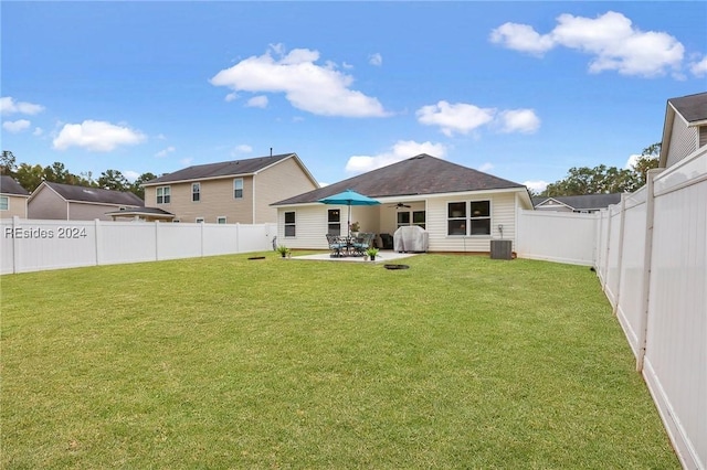 rear view of property featuring central AC unit, a patio area, and a lawn