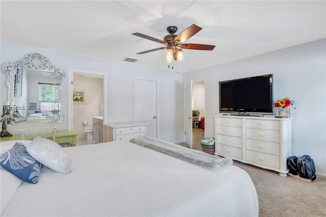 carpeted bedroom featuring ceiling fan and ensuite bath